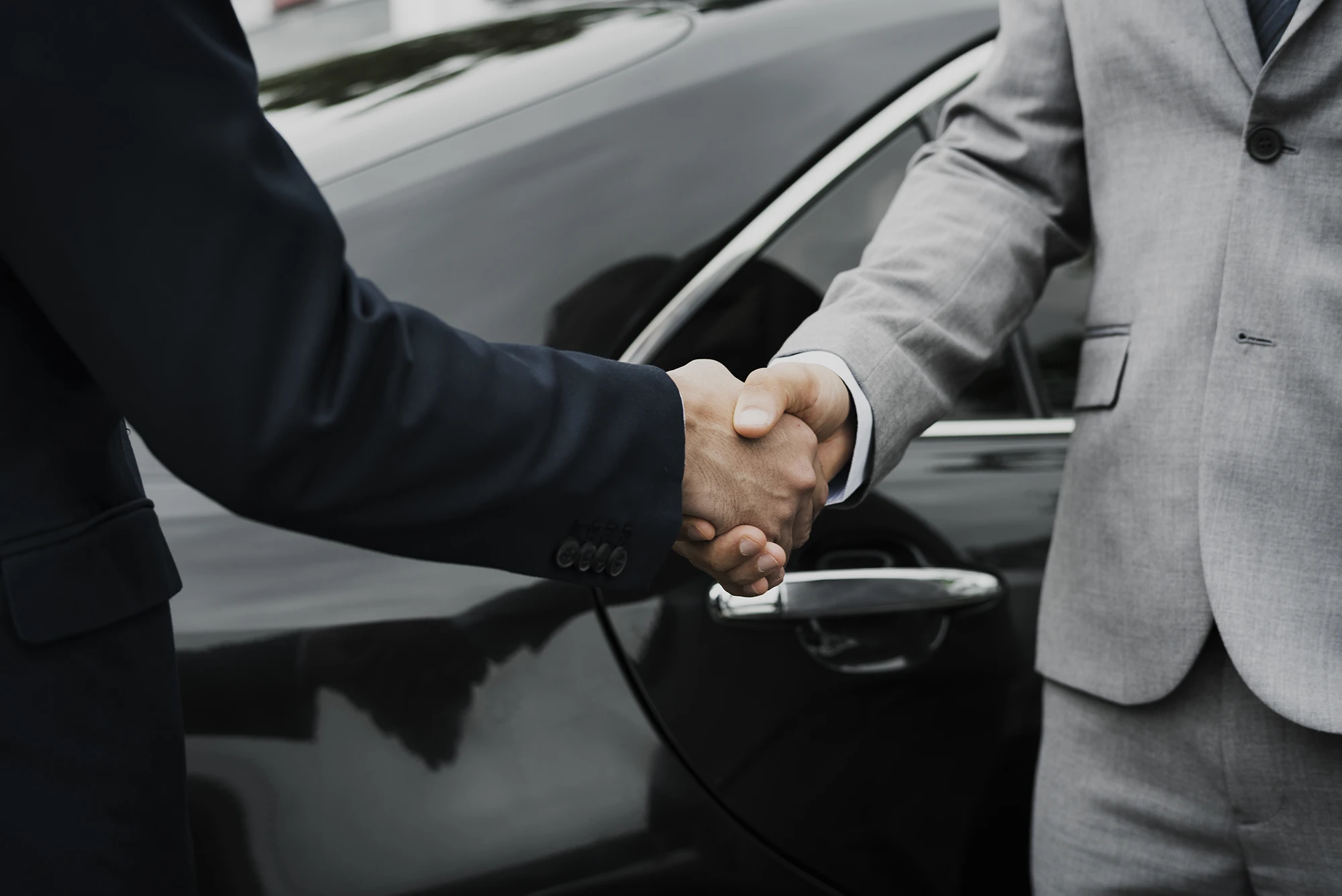 handshake in front of ev car